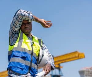 Worker shielding eyes from the sun.